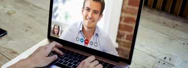 Person having a video call on a laptop with a professional wearing a blue shirt, representing virtual banking consultation.